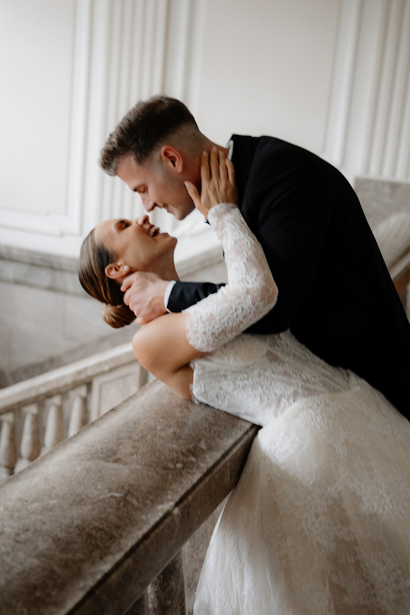 Hochzeitsfotograf Düsseldorf – inniger Kussmoment auf eleganter Marmortreppe